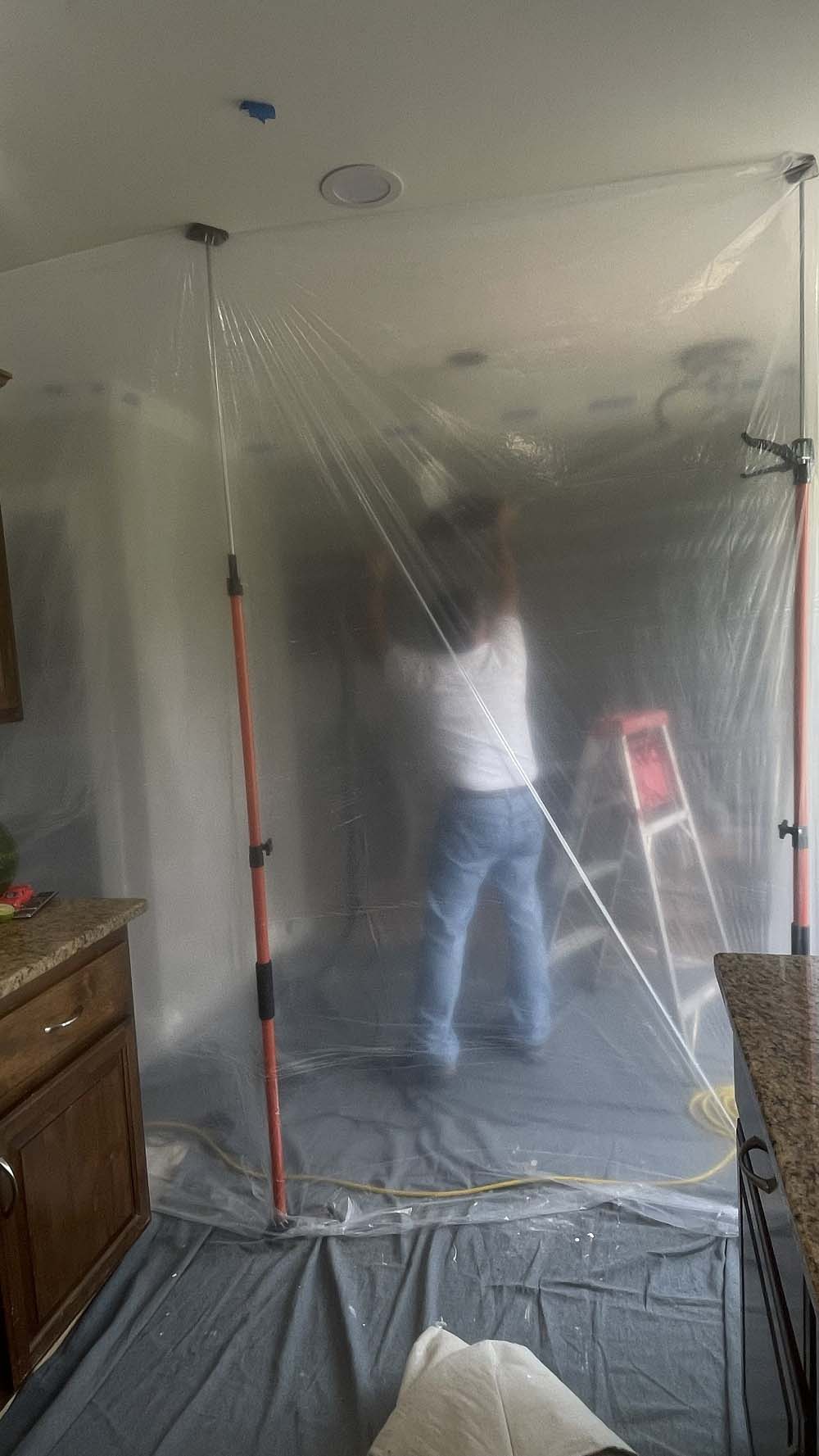 Vacuum hose and extractor stationed at hallway containment barrier
